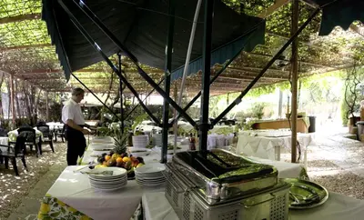 a man standing in front of a table with plates of food at Hotel Delle Muse in Rome