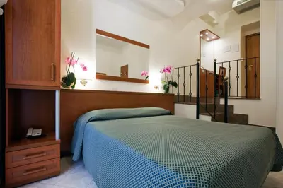 a bedroom with a blue bed and a mirror at Hotel Delle Muse in Rome