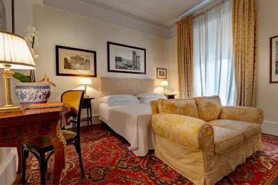 a hotel room with a bed and a couch at Grand Hotel Plaza in Rome
