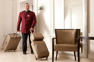 a man is standing with luggage and a chair at Hotel Mascagni in Rome