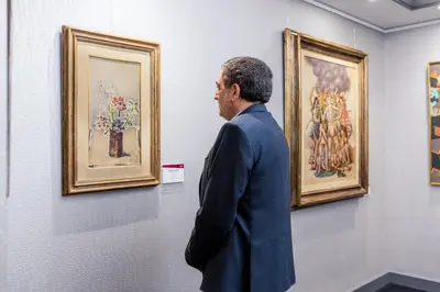 a man in a suit looking at art on a wall at Hotel Artemide in Rome