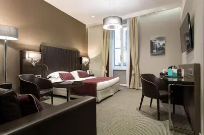 a hotel room with a bed and a table and chairs at Hotel Artemide in Rome