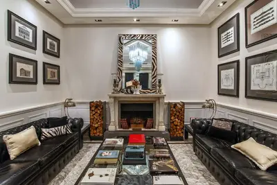 a living room with black leather couches and a fireplace at Hotel Isa in Rome