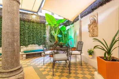 a patio with chairs and a table and a plant at Hotel Medici in Rome