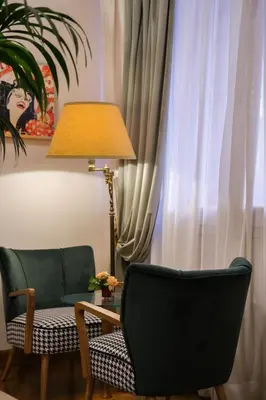 a living room with blue couches and a chandelier at Hotel Medici in Rome