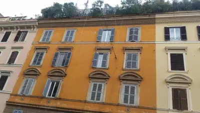 an orange building with white windows on a street at Barbara Vaticano Affitti Brevi in Rome