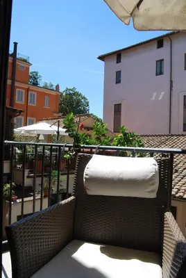 a wicker chair with a towel on a balcony at Pettinary Village B&B in Rome