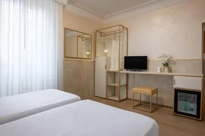 a hotel room with two beds and a television at Hotel Palladium Palace in Rome