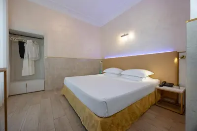 a bedroom with a large white bed in a room at Hotel Palladium Palace in Rome