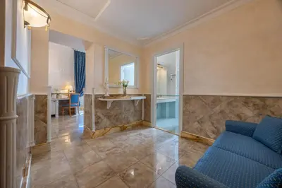 a living room with a blue couch and a table at Hotel Palladium Palace in Rome