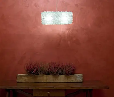 a potted plant on a table in front of a red wall at Hotel Columbia in Rome