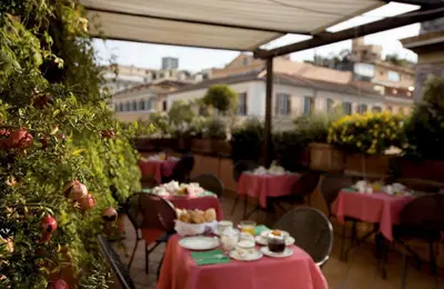 a patio with tables and chairs with pink table cloth at Hotel Columbia in Rome