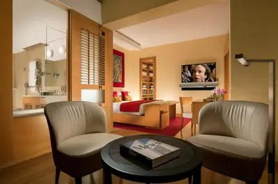 a living room with two chairs and a table at Hotel Raphaël - Relais & Châteaux in Rome