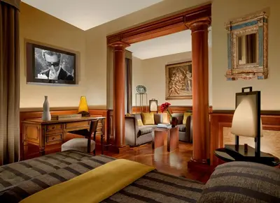 a bedroom with a bed and a desk and a chair at Hotel Raphaël - Relais & Châteaux in Rome