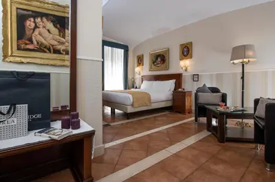 a hotel room with a bed and a living room at Hotel Des Artistes Roma in Rome
