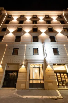 a building with lights on the side of it at Hotel Des Artistes Roma in Rome