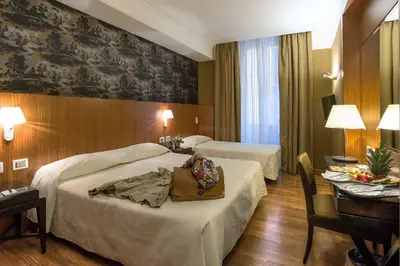 a hotel room with two beds and a table at Albergo del Senato in Rome