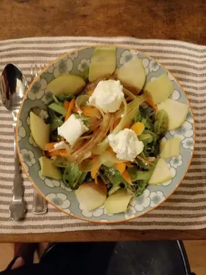 a plate of food with a salad on a table at City Guest House in Rome
