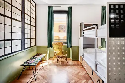 a small room with bunk beds and a chair at Generator Rome in Rome