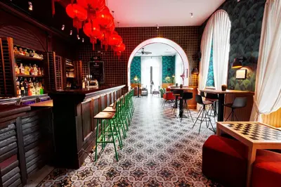 a restaurant with a bar with green chairs at Generator Rome in Rome