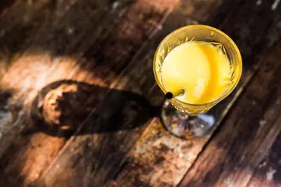 a glass of orange juice sitting on a wooden table at Generator Rome in Rome