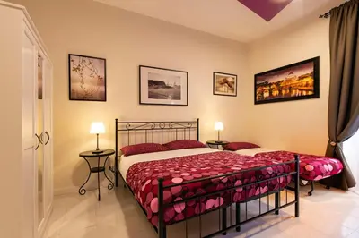 a bedroom with a bed and two lamps and pictures on the wall at Giulio Cesare Imperatore in Rome