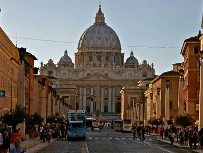 a blue bus driving down a street in front of a building at Giulio Cesare Imperatore in Rome