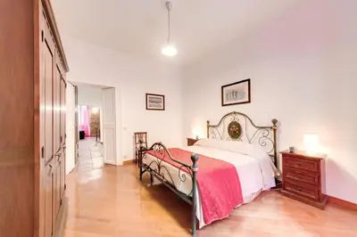 a bedroom with a large bed and a wooden floor at Nova Domizia in Rome