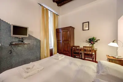 a bedroom with a bed and a desk and a television at Nova Domizia in Rome