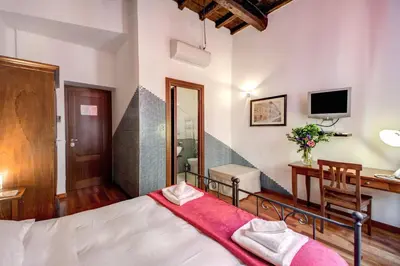a bedroom with a bed and a desk and a television at Nova Domizia in Rome