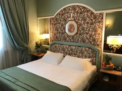 a bedroom with a large bed with a floral wall at Hotel Mecenate Palace in Rome