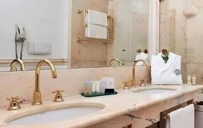 a bathroom with two sinks and a large mirror at Hotel Mecenate Palace in Rome