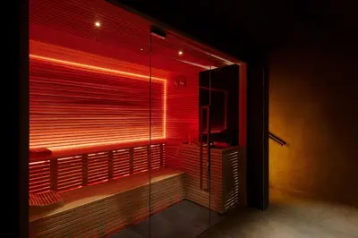 a bathroom with a glass shower with red lighting at art'otel Rome Piazza Sallustio in Rome