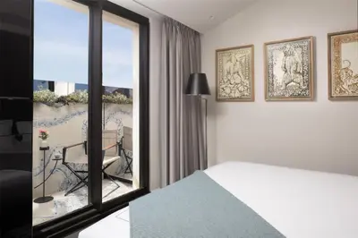 a bedroom with a bed and a view of a balcony at art'otel Rome Piazza Sallustio in Rome