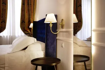 a hotel room with a bed and two tables at Hotel Silva in Rome