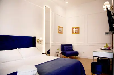 a bedroom with a bed and a blue chair at Hotel Silva in Rome