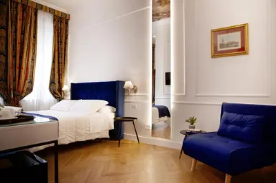 a bedroom with a bed and a blue chair at Hotel Silva in Rome