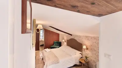 a bedroom with a bed and a green chair at Hotel Silva in Rome