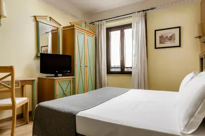 a hotel room with a bed and a television at Exe Domus Aurea in Rome