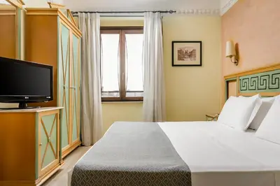 a hotel room with a bed and a television at Exe Domus Aurea in Rome
