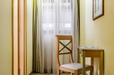 a chair and a table in a room with a window at Exe Domus Aurea in Rome