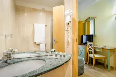 a bathroom with a tub and a sink and a desk at Exe Domus Aurea in Rome