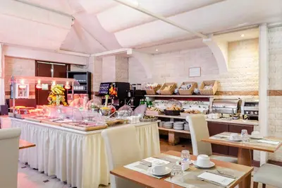 a restaurant with tables and chairs and a buffet at Exe Domus Aurea in Rome