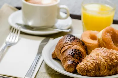 a plate of food with pastries and a cup of coffee at Exe Domus Aurea in Rome