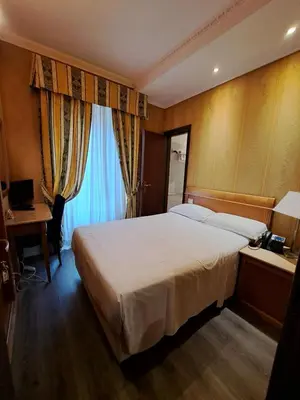 a hotel room with a bed and a desk with a computer at Hotel dei Quiriti in Rome