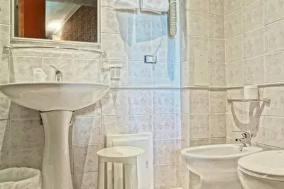 a hotel room with a large bed with white sheets and pillows at Hotel dei Quiriti in Rome