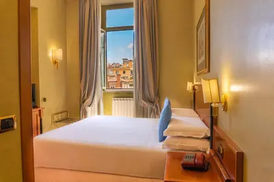a hotel room with a bed and a window at Hotel Miami in Rome