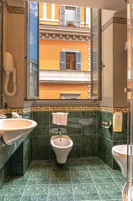 a bathroom with a toilet and a sink and a mirror at Hotel Miami in Rome