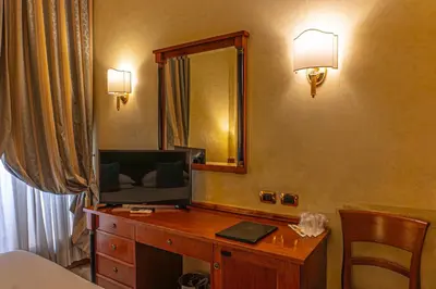 a room with a desk with a television and a mirror at Hotel Miami in Rome