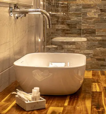 a bath tub sitting on a wooden floor in a bathroom at Hotel Miami in Rome